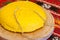 Romanian traditional dish polenta mamaliga on wooden plate sliced with a string