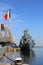 Romanian warship moored in port and romanian flag