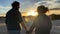 Romantic adult mature couple in love enjoying together an amazing outdoors sunset holding hands and looking each other. Family in