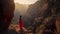 Romantic aerial photo of a girl in a red dress on top of a cliff admiring the view of a mountain gorge.