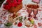 Romantic aesthetic pink picnic with tablecloth marshmallows, macaroons, strawberries, glasses of wine among pink roses