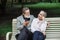 Romantic aged couple sitting on wooden bench at green park