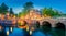 Romantic Amsterdam lit the lights. Evening panoramic view of the famous historic center with lantern lights, bridges, canals and