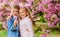 Romantic babies. Kids enjoying pink cherry blossom. Tender love feelings. Couple kids on flowers of sakura tree