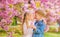 Romantic babies. Tender love feelings. Couple kids on flowers of sakura tree background. Little girl enjoy spring