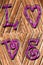 Romantic background on antique wood and purple word love impressed above