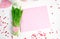 Romantic background in pink tones with hearts, pink envelope and green bouquet on a light background.