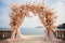 Romantic beachside vows Peach arch, blossoms, sea view, and vases of flowers