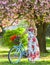 Romantic bike ride. Spring holidays. Tourism concept. Transportation and travel. Sakura season. Woman with tulips