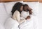 Romantic black couple hugging while sleeping in bed