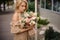 Romantic blonde woman holding a nude beige bouquet of flowers