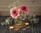 A romantic bouquet of pink gerberas in a glass vase. Gypsophila flowers, candles, envelopes as decor