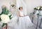 Romantic bridal morning. A beautiful bride in elegant white dress sitting in a chair and dreams of a wedding day