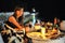 Romantic candlelit dinner by the sea at night. Beautiful young girl at the table