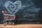 Romantic cart Heart doodles accompany small shopping cart on blackboard backdrop