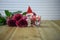 Romantic christmas winter season photography image with red roses and a lit candle with marshmallow snowman decoration