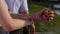 Romantic closeup of a young man s hand holding a young woman s hand when the happy couple is standing in the park near