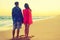 Romantic couple bathing with towels on beach sunset