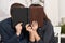 Romantic couple drinking tea with cookies, kissing behind photo album