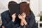 Romantic couple drinking tea with cookies, kissing behind photo album