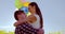 Romantic couple holding colorful balloons and embracing each other in mustard field