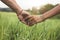 Romantic couple holding hands in a field