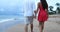 Romantic couple holding hands walking on beach in elegant casual clothing