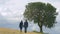 Romantic couple holding hands, walking life journey together, kissing under tree