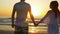 Romantic couple holding hands and walking towards the water - on sandy beach