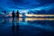 Romantic couple holding hands watching the sunset on the beach