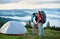 Romantic couple of lovers active rest in mountains at morning near camping