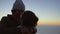 Romantic couple on mountain peak at sunset having fun
