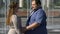 Romantic couple of overweight people kissing and hugging outdoors, relationship