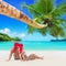 Romantic couple in red Christmas Santa hats sunbathe at tropical palm sandy island beach