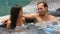 Romantic couple relaxing together in hot tub whirlpool jacuzzi luxury resort