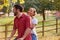 Romantic Couple Riding Bike Along Country Lane At Sunset