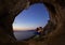 Romantic couple of rock climbers in cave at sunset