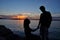 Romantic couple silhouette over sea sunset background