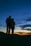 Romantic couple silhouetted against a beautiful night sky on mountain top