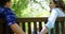 Romantic couple sitting hand in hand on bench in park