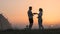 The romantic couple sitting near the campsite tent and preparing tea.