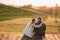 Romantic Couple sitting on the pier in autumn nature.