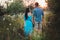 Romantic couple standing back in the sunset light in the park, holding hands