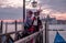 Romantic couple in traditional costume and masks standing with back to the Grand Canal and San Giorgio, Venice, Italy