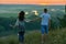 Romantic couple walk on hill at sunset on country outdoor, girl with bouquet of wild flower, beautiful landscape and bright yellow