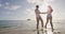 Romantic couple walking at beach at sunset dancing around holding hands