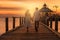 A romantic couple walking hand in hand on a pier at sunset, surrounded by vintage beach props and capturing the magic of summer