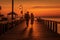 A romantic couple walking hand in hand on a pier at sunset, surrounded by vintage beach props and capturing the magic of summer