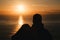 Romantic couple watching the sunset in the ocean. Silhouette