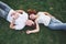 Romantic couple of young people lying on grass in park. They look happy. View from above.
